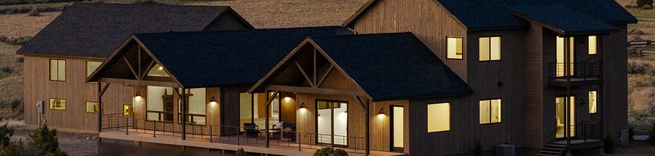 Custom home at dusk with a lit covered deck